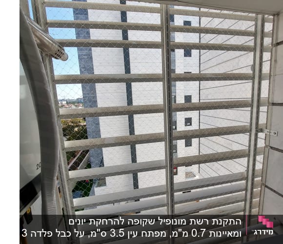 רשת מתכת מותקנת על חלון למניעת כניסת יונים